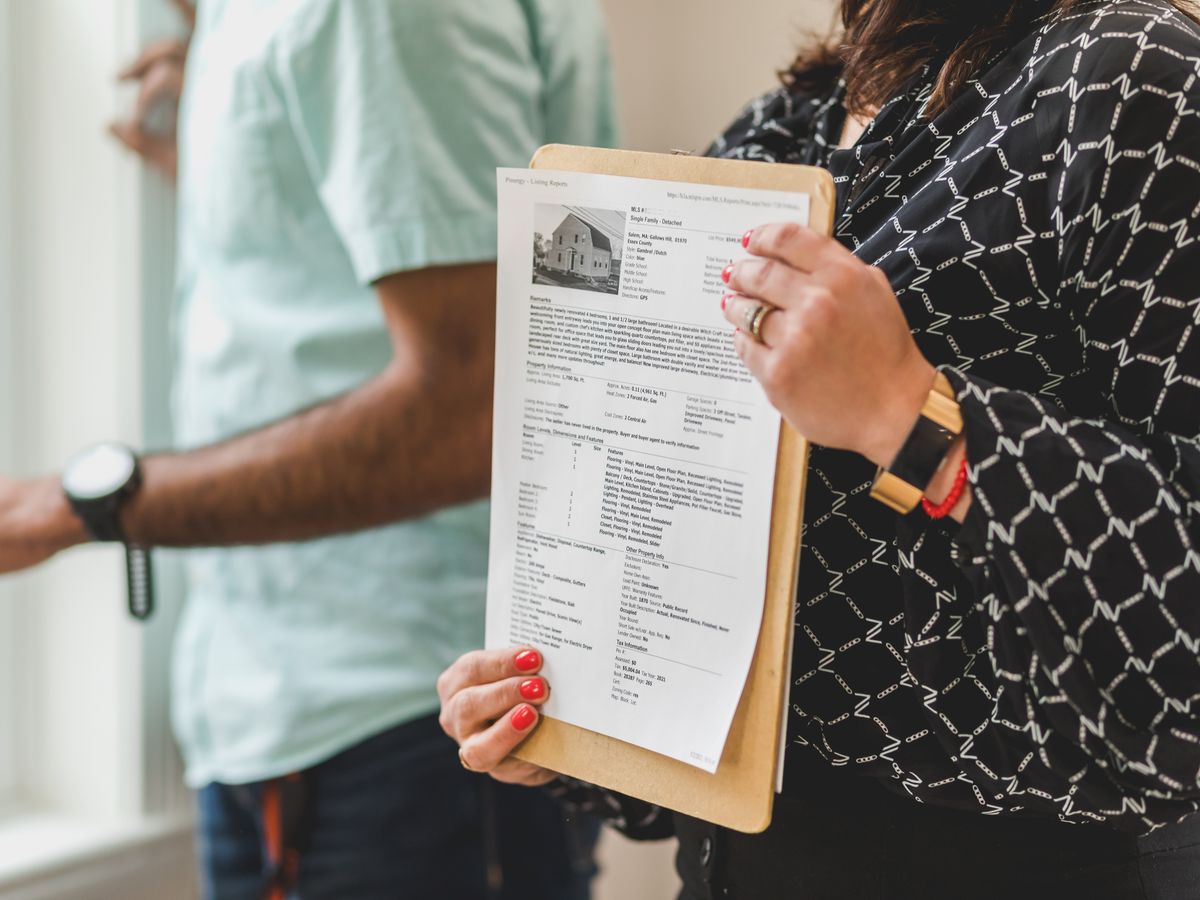 Conseillère immobilière africaine présentant une annonce de bien à un client
