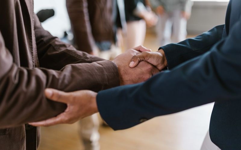 Poignée de main entre partenaires — accord immobilier sécurisé